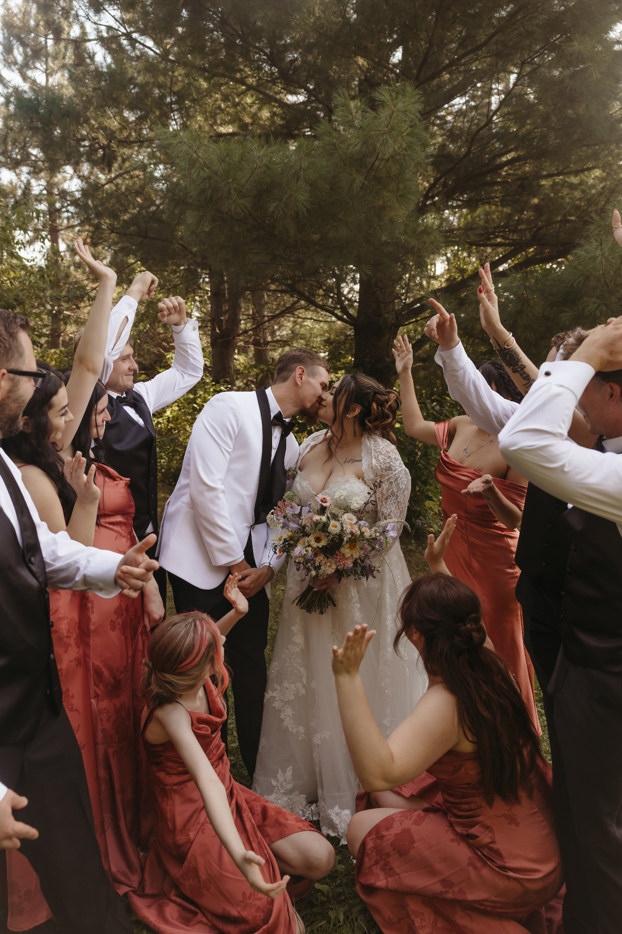 Bridal party cheering around the couple